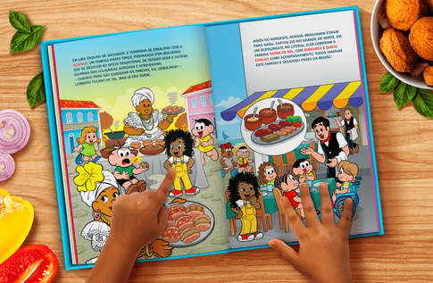 Foto de uma criança com seu livro personalizado da Turma da Mônica - Comidas Típicas