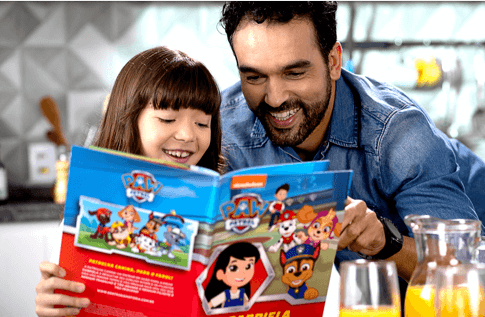 Pai e filha leem juntos o livro da Patrulha Canina - Resgate Animal
